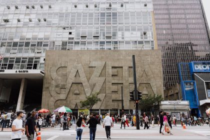 Pedestres caminham em uma rua movimentada diante do edifício Gazeta, na Avenida Paulista, em São Paulo.