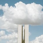 Vista do Congresso Nacional em Brasília sob um céu com nuvens.