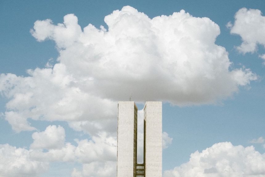 Vista do Congresso Nacional em Brasília sob um céu com nuvens.