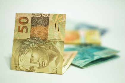 Cédula de 50 reais em destaque sobre outras notas brasileiras.