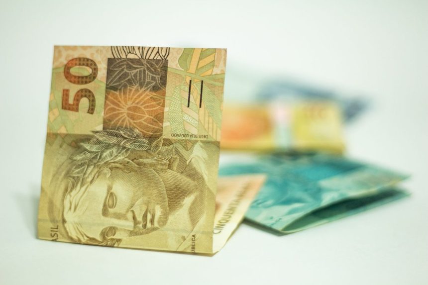 Cédula de 50 reais em destaque sobre outras notas brasileiras.