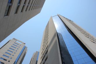 Vista de edifícios modernos de Assunção sob céu azul, representando o contexto econômico do Paraguai.